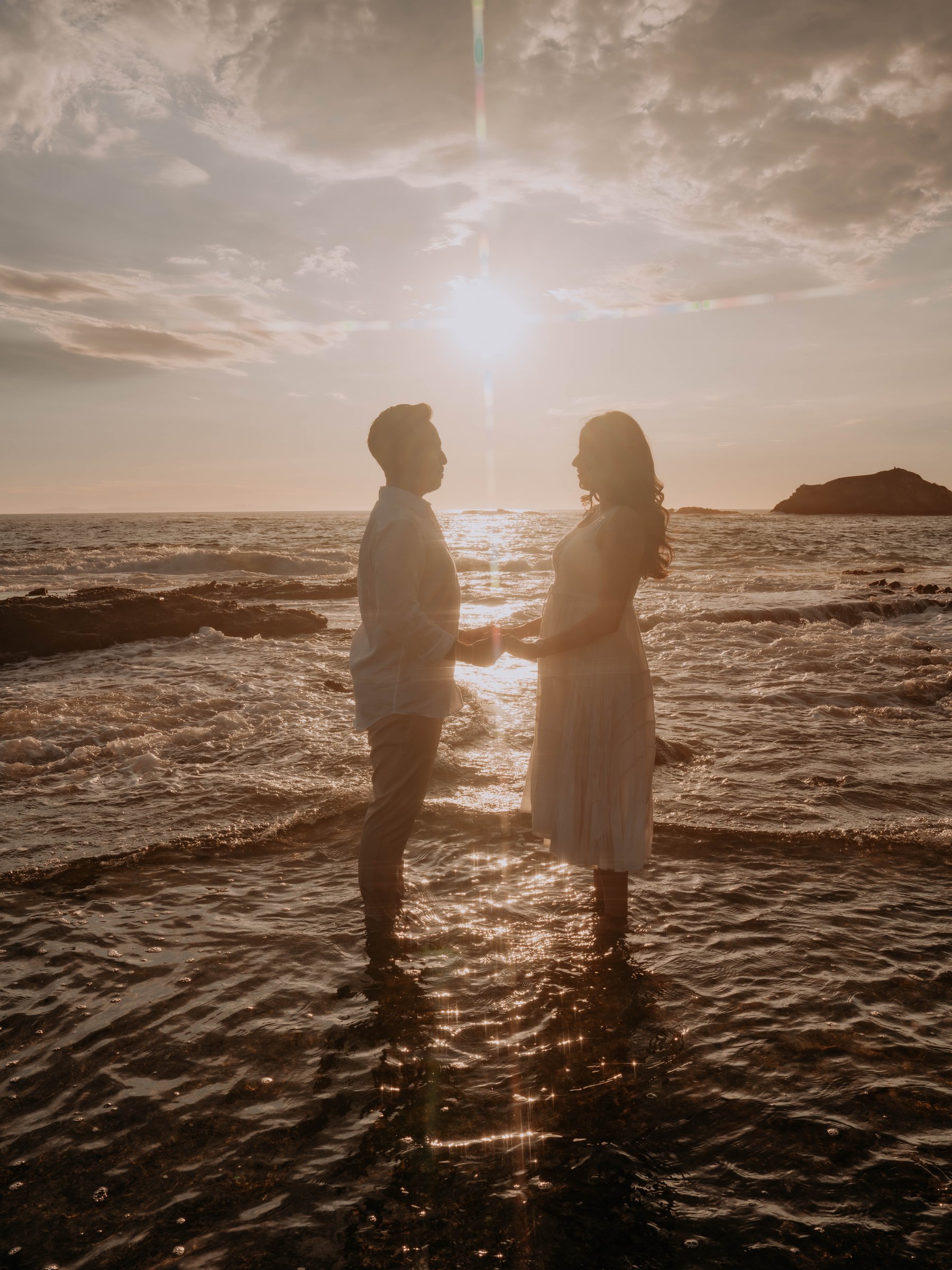 Guadalupe and Harrison with arms around each other, close-up by the ocean