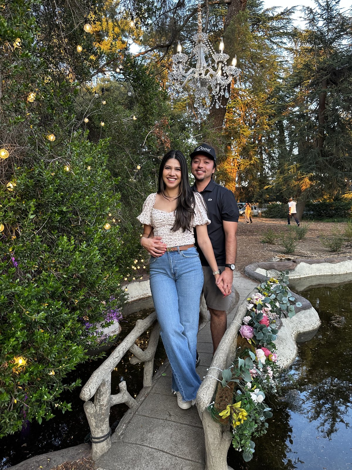 Guadalupe and Harrison at a lavender festival, string lights in the trees behind them